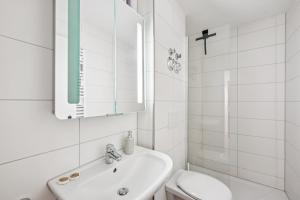 a bathroom with a sink and a toilet and a mirror at Ramoni Apartments - NaturTraum Kniebis in Freudenstadt