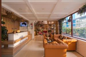 a living room with leather furniture and a large window at Sweet Lavender Hotel - Ngay chợ đêm Đà Lạt in Da Lat