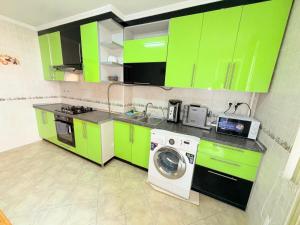 a kitchen with green cabinets and a washing machine at 1 Double Budget Room Center Park in Chişinău