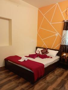 a bedroom with a bed with a red blanket at Adb's Arangan Kudil Homes in Tiruchirappalli