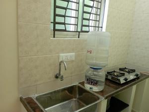 a kitchen sink with a blender on top of it at Adb's Arangan Kudil Homes in Tiruchirappalli