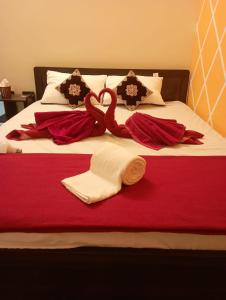 a bed with towels and swans on it at Adb's Arangan Kudil Homes in Tiruchirappalli