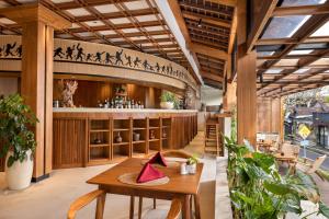 a restaurant with a table and a bar at Anumana Ubud Hotel in Ubud