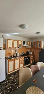 a kitchen with wooden cabinets and a white refrigerator at Casa Aly Bușteni- Casa la cheie in Buşteni