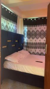 a bedroom with a bed with a blue headboard at Leisure guest in Diani Beach