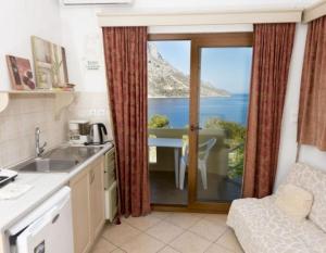 a kitchen with a window with a view of the ocean at Dimitrakis Studios in Masouri