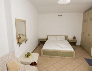 a bedroom with a bed and a mirror and a couch at Dimitrakis Studios in Masouri +2 photos
