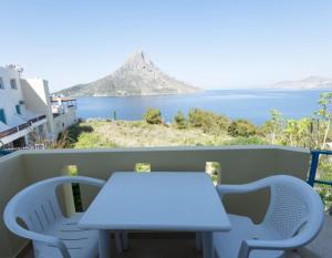 a white table and chairs on a balcony with the ocean at Dimitrakis Studios in Masouri