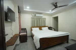 a bedroom with a bed and a flat screen tv at v square inn in Visakhapatnam