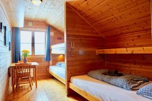 a log cabin bedroom with two bunk beds and a table at Guesthouse / Huskyfarm Innset in Innset