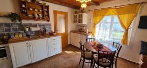 a kitchen with a table and chairs and a window at Stateček plný zvířátek in Žlebské Chvalovice