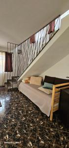 a bedroom with a bed under a staircase at Casa Aly Bușteni- Casa la cheie in Buşteni