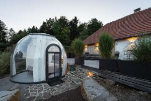 a glass dome is sitting on a patio next to a house at Chalet Weidehaus De Luxe in Obertriesting
