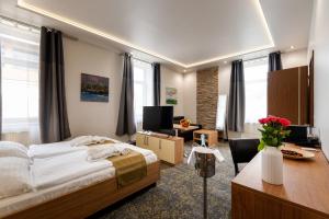 a bedroom with a large bed and a desk with a desk at Hotel Garzon Plaza in Győr