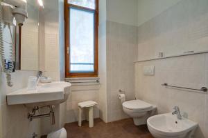 a white bathroom with a sink and a toilet at Hotel Primula in Alassio +43 photos