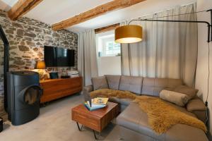 a living room with a couch and a tv at Chalet Weidehaus De Luxe in Obertriesting +31 photos