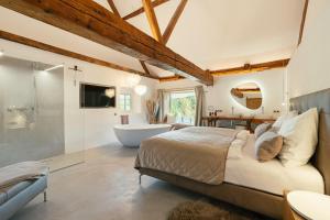 a bedroom with a large bed and a bath tub at Chalet Weidehaus De Luxe in Obertriesting