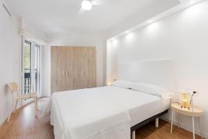 a white bedroom with a white bed and a window at Bellavista Apartamento Marmen in Málaga