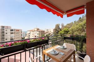a balcony with a table and chairs and flowers at Bellavista Apartamento Marmen in Málaga