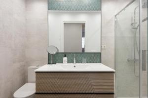 a bathroom with a sink and a toilet and a mirror at Bellavista Apartamento Marmen in Málaga