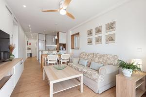 a living room and kitchen with a couch and a table at Bellavista Apartamento Marmen in Málaga +18 photos