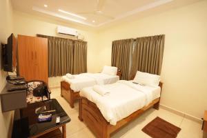 a hotel room with two beds and a television at v square inn in Visakhapatnam