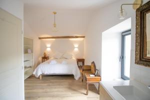 a white bedroom with a bed and a bathroom at A Casa D'amore in Bastelica +21 photos