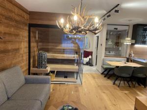 a living room with a couch and a chandelier at Tauplitzrausch Lodge in Tauplitz
