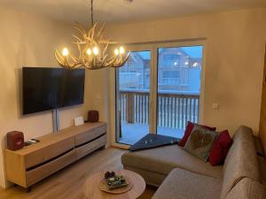 a living room with a couch and a flat screen tv at Tauplitzrausch Lodge in Tauplitz