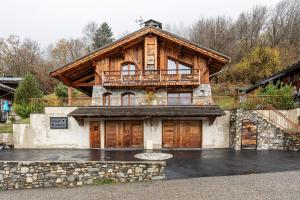 a large wooden house with a balcony on top of it at Chalet Bordon in Champagny-en-Vanoise