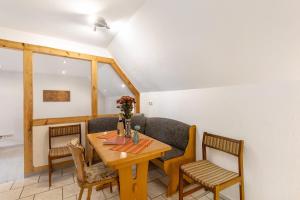 a dining room with a wooden table and chairs at Ferienwohnung Sonnenblume in Rhadern