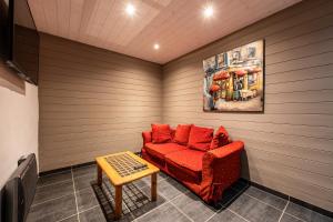 a small room with a red couch and a table at Chalet Bordon in Champagny-en-Vanoise