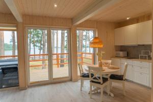 a kitchen with a table and chairs and a balcony at Czarnowodzianka domki w pierwszej linii brzegowej z widokiem na jezioro in Borsk +26 photos