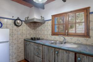 a kitchen with a sink and a refrigerator at Casa Azul - Vejer, El Palmar in Vejer de la Frontera +15 photos
