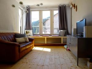 a living room with a couch and a large window at Fewo Moonshine 79 in St. Blasien