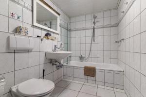 a white bathroom with a toilet and a sink at Casa Bianca in Offenburg +12 photos