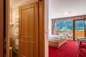 a bedroom with a bed and a balcony at Hotel Residence Gardena Stevia 307 in Santa Cristina Gherdëina