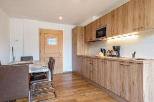 a kitchen with wooden cabinets and a table with chairs at Hotel Residence Gardena Stevia 307 in Santa Cristina Gherdëina