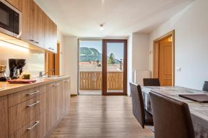 a kitchen with a table and chairs and a large window at Hotel Residence Gardena Stevia 307 in Santa Cristina Gherdëina +22 photos