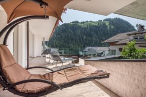 a chair on a balcony with a view of a mountain at Hotel Residence Gardena Stevia 307 in Santa Cristina Gherdëina