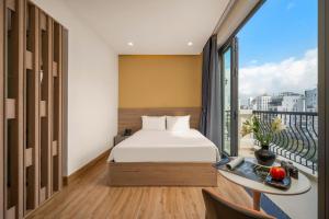 a bedroom with a bed and a balcony at Mai Living Apartment in Danang