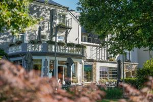 a large white building with a balcony on it at Hotel Le Charme de la Semois in Alle
