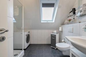 a white bathroom with a sink and a washing machine at Micha's Ferienwohnung in Bredstedt +19 photos