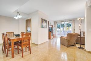 a dining room and living room with a table and chairs at Puerto Romano in Denia
