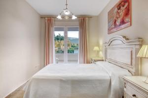 a bedroom with a white bed and a window at Puerto Romano in Denia +18 photos