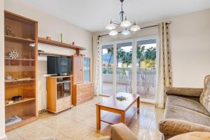 a living room with a couch and a tv at Puerto Romano in Denia