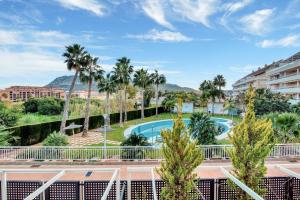 a view from the balcony of a resort with a pool and palm trees at Puerto Romano in Denia