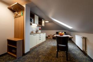 a kitchen with a table and a chair in a room at Hotel Garzon Plaza in Győr