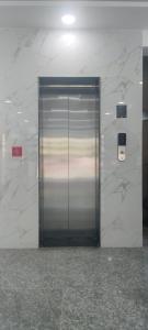 a metal elevator in a building with a marble wall at Chouhan Resort in Katihār