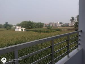 a view of the fields from the balcony of a house at Chouhan Resort in Katihār